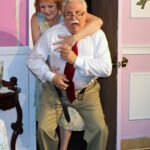 smiling red hair woman on a surprised looking elderly mans back -sex please, we're sixty